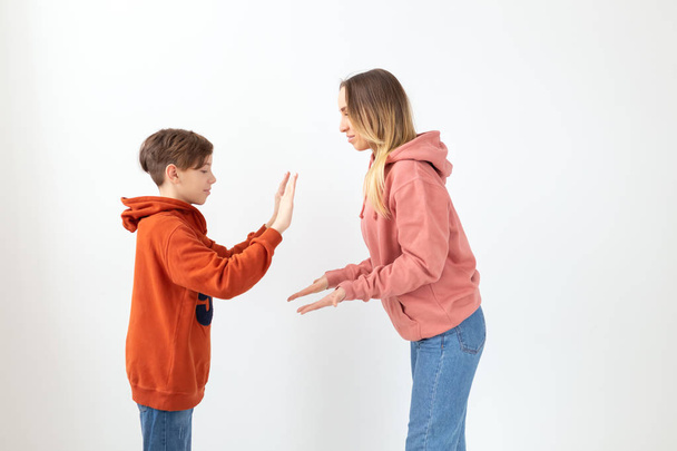 Relatie, Moederdag, kinderen en familie concept - tiener jongen geven hoge vijf aan zijn moeder op witte achtergrond - Foto, afbeelding