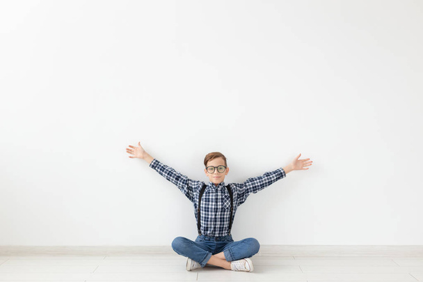 teenager, children and fashion concept - kid dressed in plaid shirt posing over white background - Photo, Image