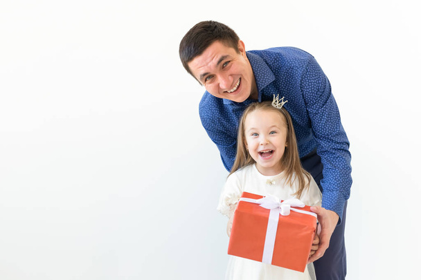 пішохідна, батьківська та сімейна концепція - щасливий тато тримає подарункову коробку зі своєю дочкою на білому тлі з місцем для тексту
 - Фото, зображення