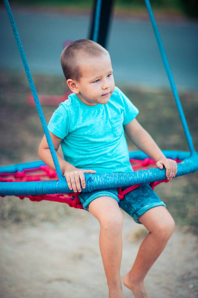 Little boy swinging on a swing - Фото, зображення