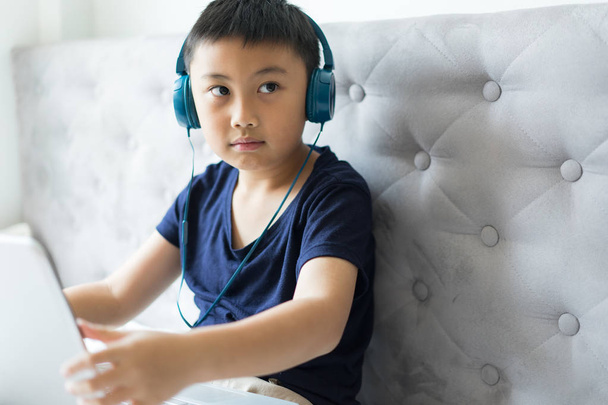 Μικρό αγόρι, χρησιμοποιώντας φορητό υπολογιστή παιχνίδι παιχνίδι στο σπίτι για να χαλαρώσετε - Φωτογραφία, εικόνα