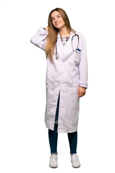 Ganzkörper junge Ärztin denkt eine Idee, während sie Kopf auf isoliertem Hintergrund kratzt - Foto, Bild