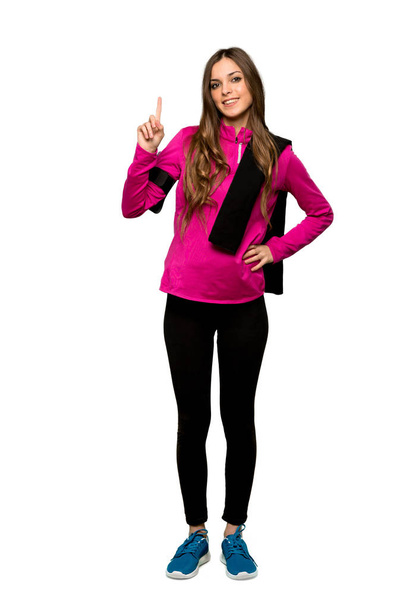 Full-length shot of Young sport woman showing and lifting a finger in sign of the best over isolated white background - Photo, Image