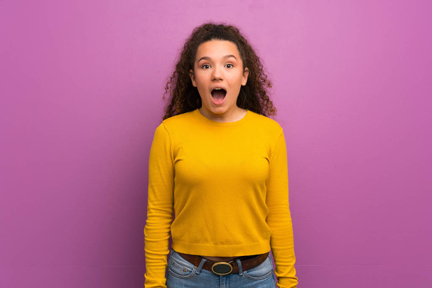 Adolescente sur le mur violet avec expression faciale surprise
 - Photo, image