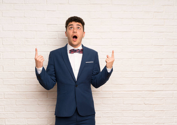 Man in suit and bow tie surprised and pointing up - Foto, Imagem
