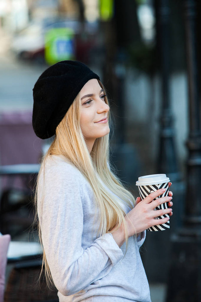 Wspaniała młoda kobieta z filiżanki kawy w ulicy miasta. Przerwa na kawę. Kawa na wynos. Hipster stylowa dziewczyna pije kawę przy ulicy. - Zdjęcie, obraz