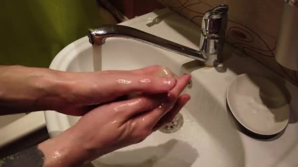 Hombre lavándose las manos en el lavabo del baño con jabón
 - Metraje, vídeo