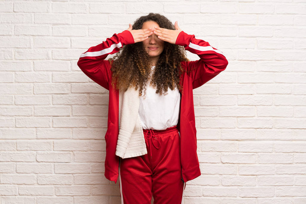 Teenager sport girl with curly hair covering eyes by hands. Surprised to see what is ahead - Foto, immagini
