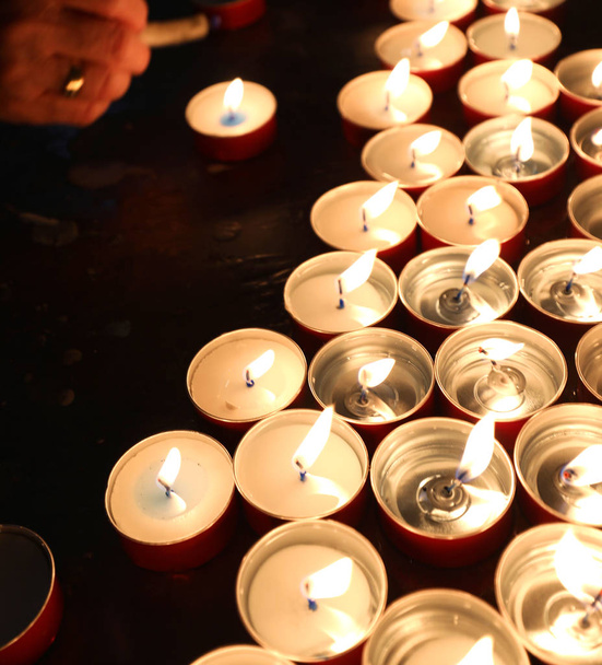 Kerzen mit flackernder Flamme im Gotteshaus - Foto, Bild