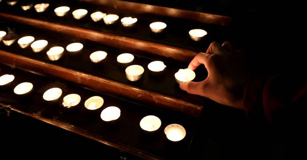χέρι με πολλά κεριά με τη φλόγα του τόπου λατρείας du - Φωτογραφία, εικόνα