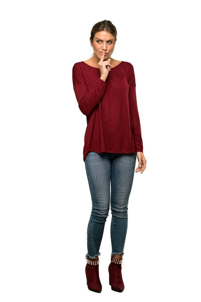A full-length shot of a Blonde woman showing a sign of silence gesture over isolated white background - Photo, Image