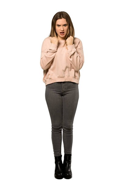 A full-length shot of a Teenager girl with pink sweater frustrated by a bad situation over isolated white background - Photo, Image
