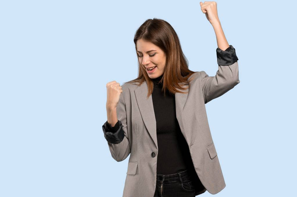 Mujer de negocios celebrando una victoria sobre fondo azul aislado
 - Foto, Imagen