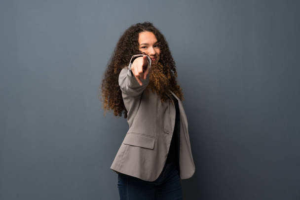 Adolescente chica sobre azul pared señala el dedo en usted con una expresión de confianza
 - Foto, imagen