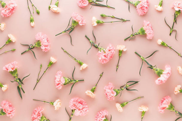 Pink carnation flowers on pastel background. Flat lay, top view, - Foto, Imagen