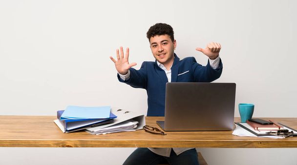 Business man in a office counting six with fingers - Foto, immagini
