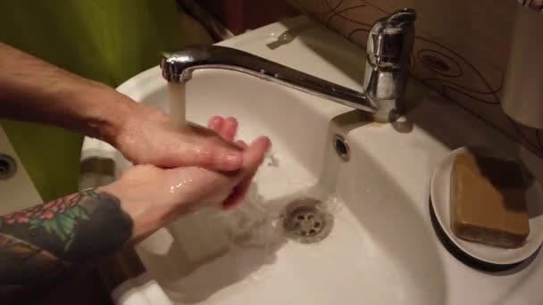 Hombre lavándose las manos en el lavabo del baño con jabón
 - Metraje, vídeo