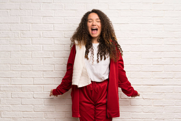 Teenager sport girl with curly hair shouting to the front with mouth wide open - Photo, Image