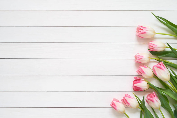 Roze tulpenboeket op witte houten achtergrond. Bovenaanzicht, kopieerruimte. Wenskaart. - Foto, afbeelding