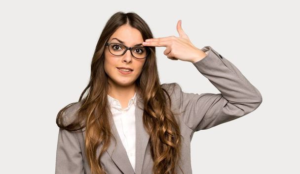 Business woman with problems making suicide gesture over isolated grey background - Photo, Image