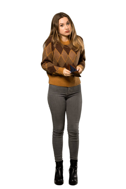 A full-length shot of a Teenager girl with brown sweater holding a wallet over isolated white background - Foto, Bild