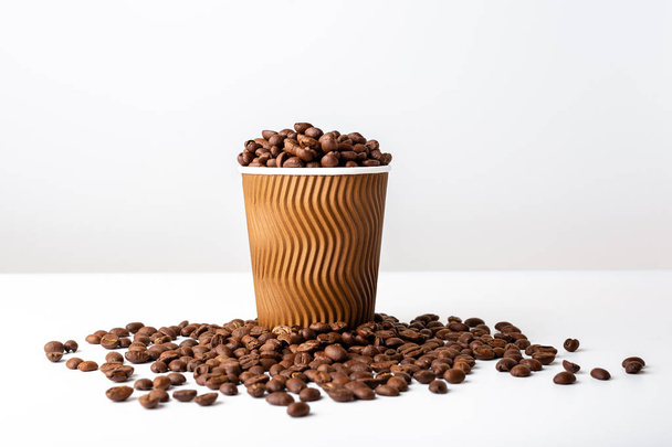 Craft coffee cup full of coffee bean on white background - Photo, image