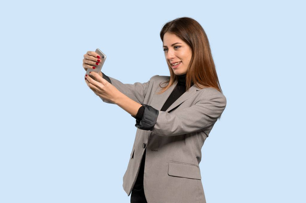 Femme d'affaires faisant un selfie sur fond bleu isolé
 - Photo, image