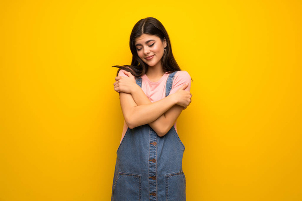 Adolescente chica sobre amarillo pared de congelación
 - Foto, imagen