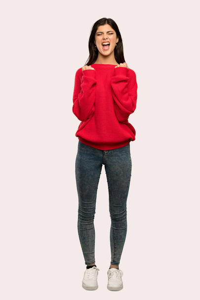 赤いセーター分離背景に悪い状況でイライラとティーンエイ ジャーの女の子のフルレングス ショット - 写真・画像