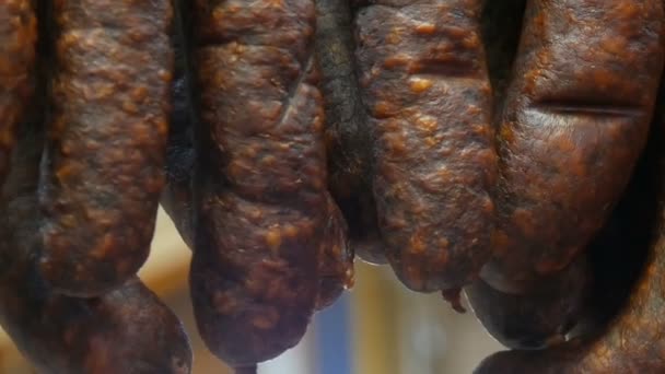 Una fila de salchichas ahumadas cuelgan de la vitrina de una carnicería
 - Metraje, vídeo
