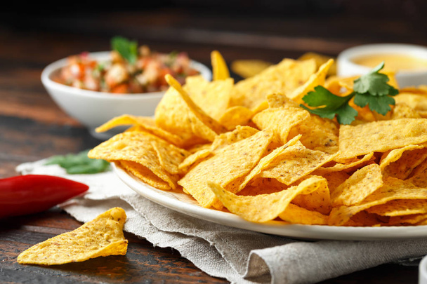 Tortilla nachos chips with cheese sauce, guacamole and tomatoes salsa dip. lime. chilli pepper. - Foto, immagini