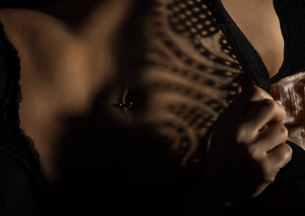 Fragment of lacy lingerie. shadow of lace on a sexy female body. play of light and shadow - Foto, imagen