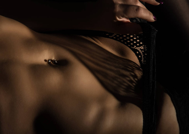 Fragment of lacy lingerie. shadow of lace on a sexy female body. play of light and shadow - Foto, Imagen