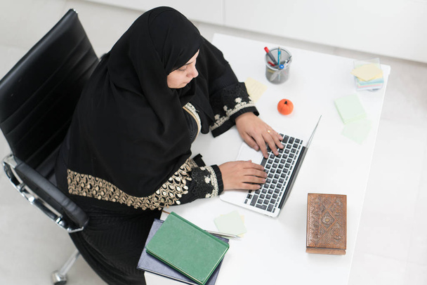Jeune femme musulmane travaillant sur ordinateur portable au bureau
 - Photo, image