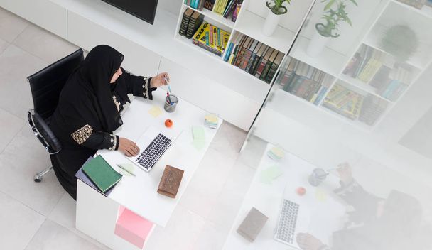 オフィスでラップトップに取り組んで若いイスラム教徒の女性 - 写真・画像