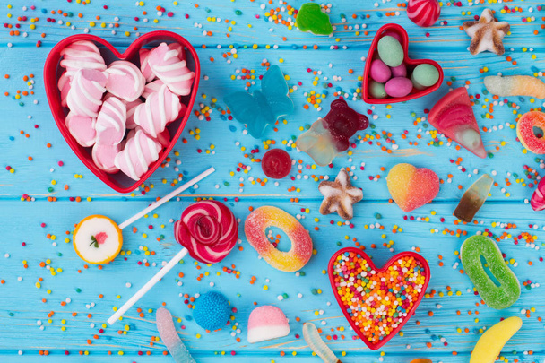 Colorful candies on blue wooden table background. - 写真・画像