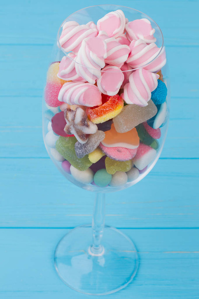 Goblet glas gevuld met kleurrijke snoepjes. - Foto, afbeelding