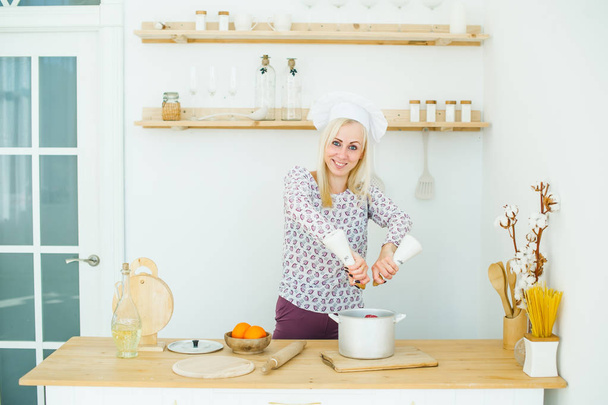 Fiatal kaukázusi nő főzés élelmiszerek a konyhában - Fotó, kép