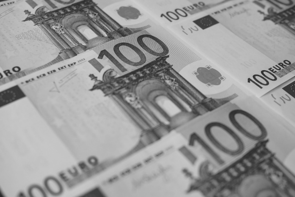 verschillende bankbiljetten van 100 euro close-up, monochroom. - Foto, afbeelding