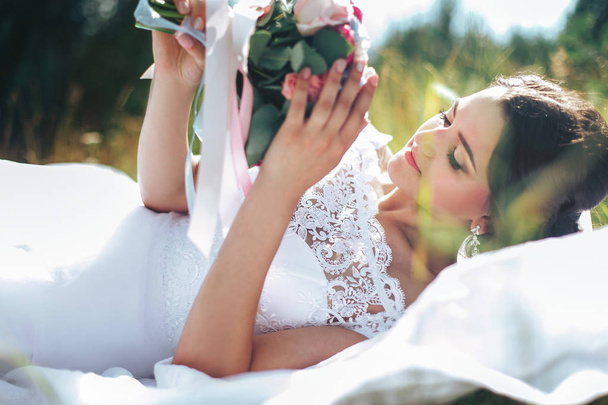 portrait of a beautiful happy bride against a green meadow and f - Фото, изображение