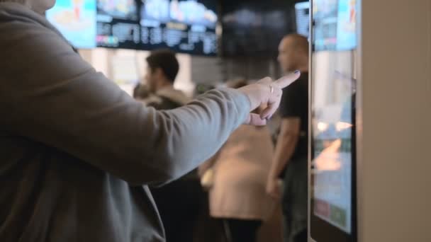 Mujer Elegir comida a través de la máquina de autoservicio en el restaurante de comida rápida. Las personas que utilizan la terminal táctil de autoservicio realizan una compra de alimentos
 - Imágenes, Vídeo