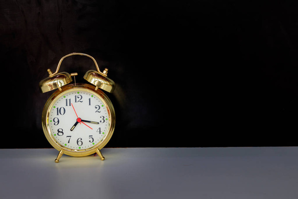 reloj despertador viejo vintage oro sobre fondo blanco y negro
 - Foto, imagen