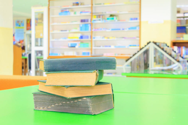 viejo libro y un montón de tratado en la biblioteca de la escuela en verde de mesa
 - Foto, imagen