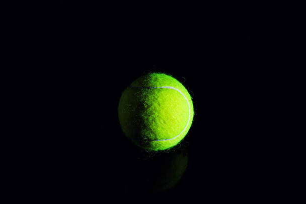 Tennis Ball isolated on black with dramatic lighting - Foto, afbeelding