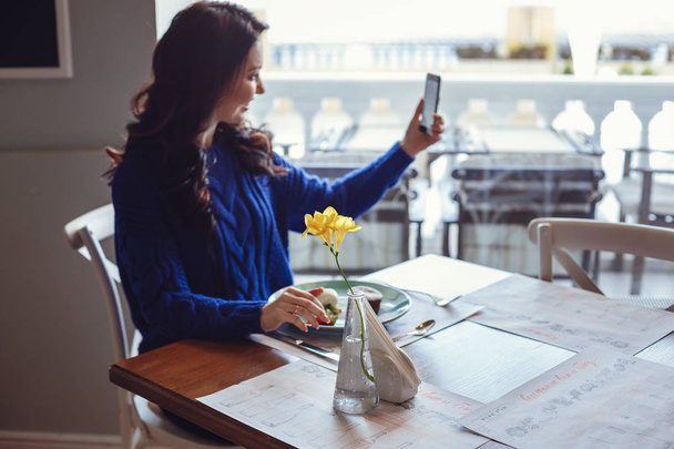 жінка в кафе сидить за столом, п'є каву і дивиться на вікно
 - Фото, зображення