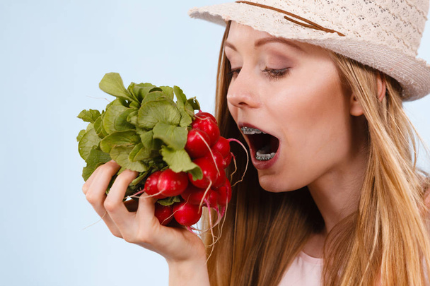 Happy woman biting radish - Foto, Imagen