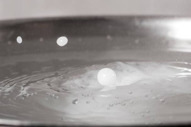 Add salt to boiling water in a metal pan close-up - Foto, imagen