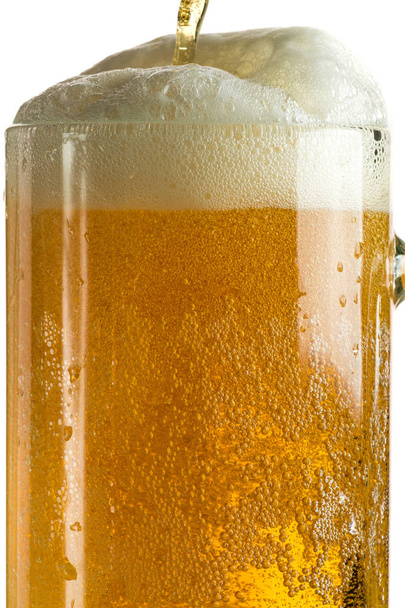 Pouring light beer in a beer mug, it turns out foam and spray - Foto, Bild