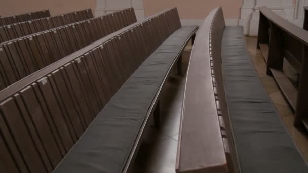 in einer leeren katholischen Kirche. Holzbänke für Kirchenmitglieder. - Filmmaterial, Video