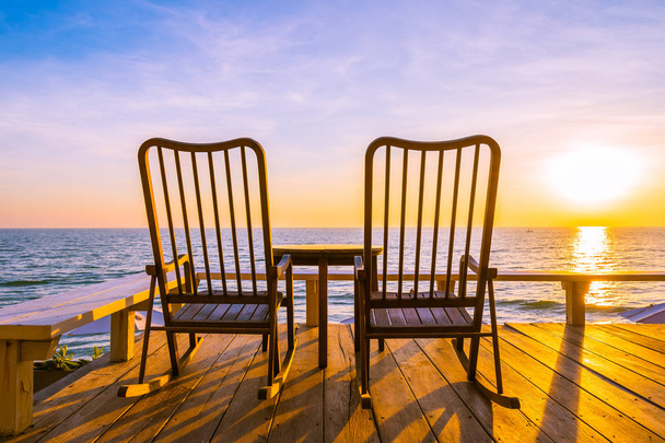 Пустой деревянный стул и стол на открытом патио с красивыми tropi
 - Фото, изображение